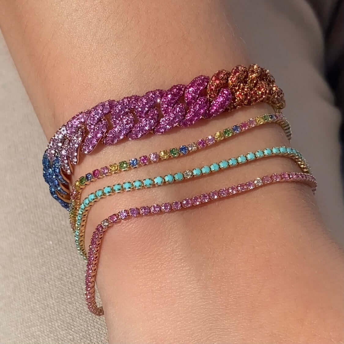Elegant wrist adorned with colorful, sparkling bracelets showcasing premium jewelry from our collection.