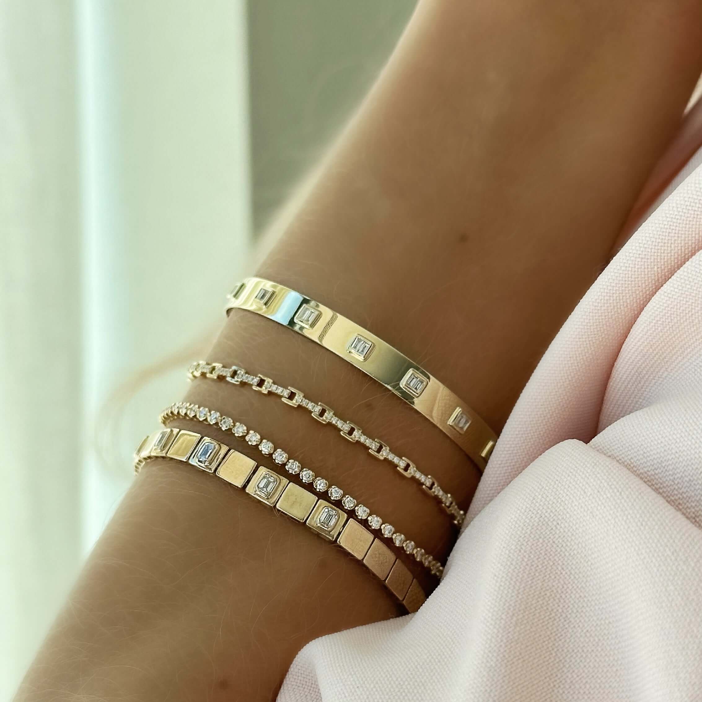 Elegant wrist with gold and diamond-studded bracelets from our jewelry collection, showcasing luxury and style in every piece.