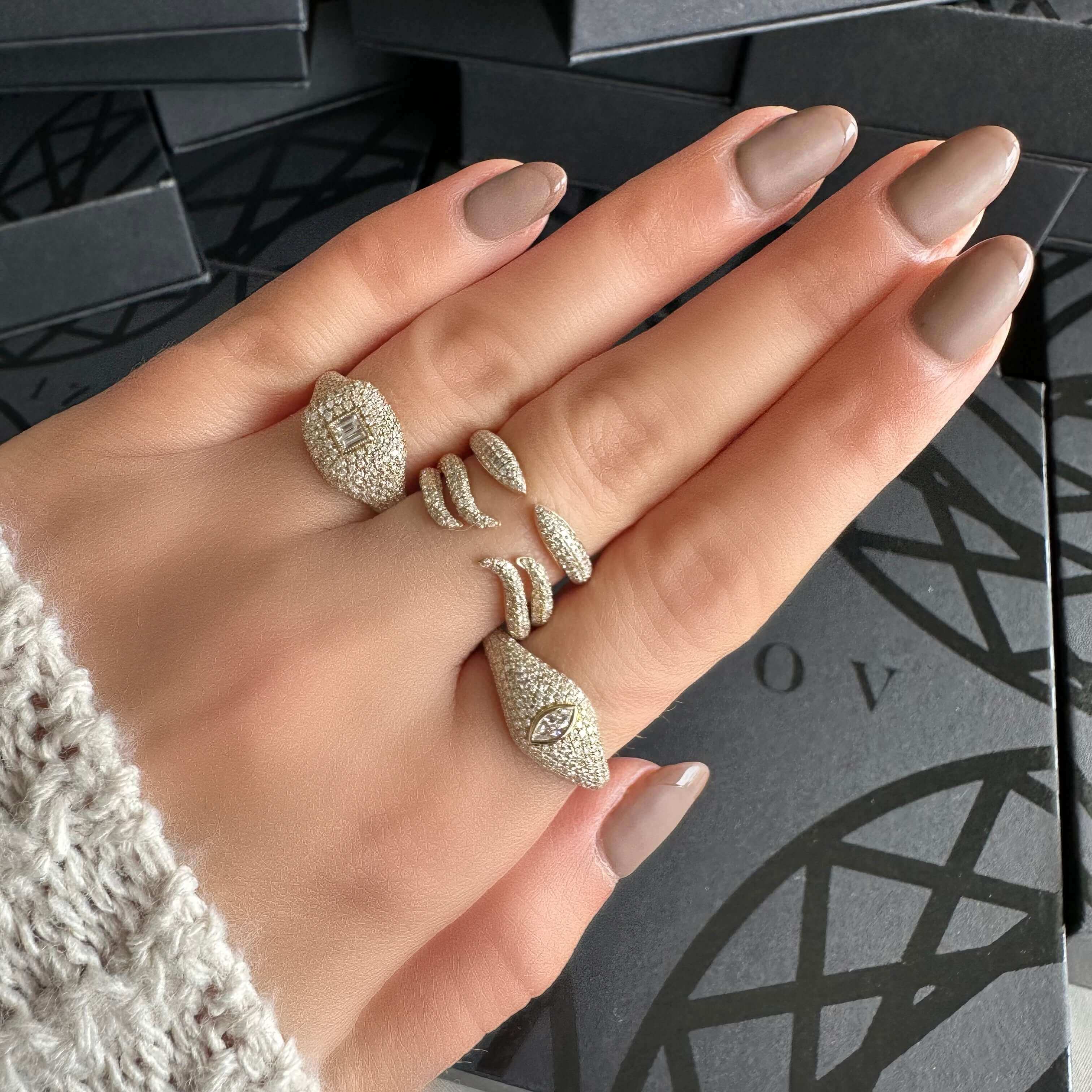 Elegant jewelry brand rings with intricate designs displayed on a woman's hand.