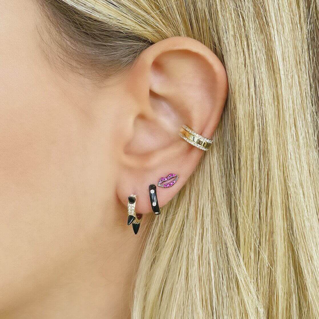 Woman showcasing stylish ear piercing jewelry with gold ear cuff and multicolored earrings from our jewelry brand collection.