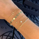 Gold and charm bracelets from our jewelry brand displayed on a wrist with elegant heart, pearl, and diamond designs.