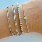 Modern and elegant silver chain and diamond bracelets stacked on wrist from our jewelry brand collection.