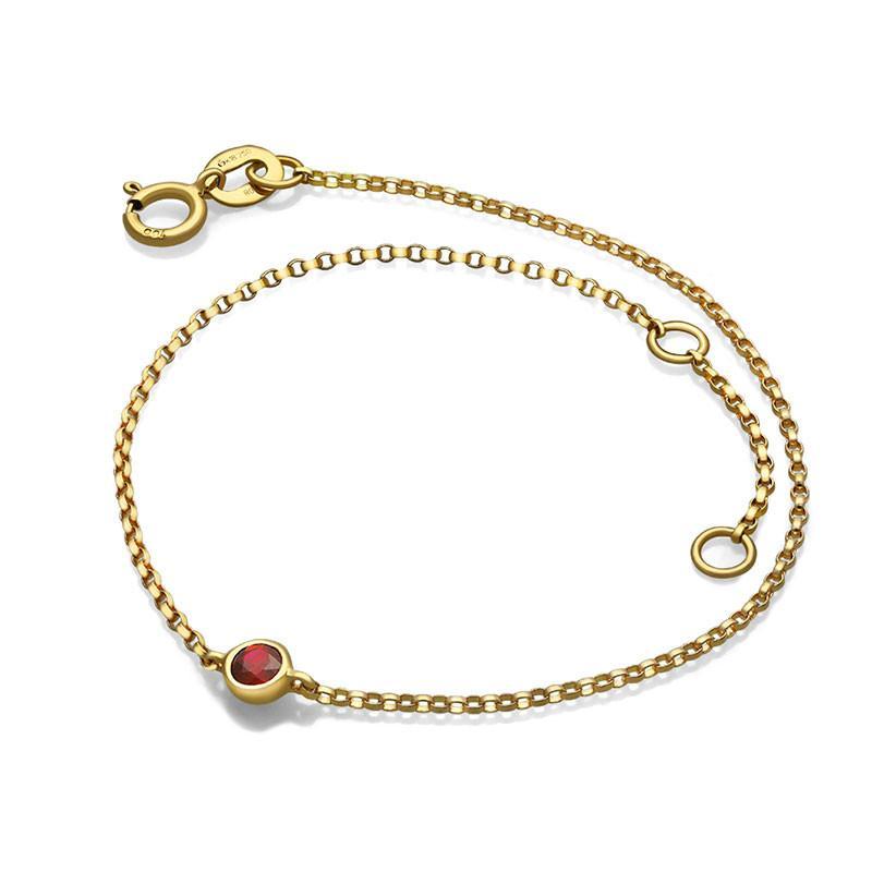 Elegant gold chain bracelet with a red gemstone, perfect for adding a touch of luxury to any outfit from our exclusive jewelry collection