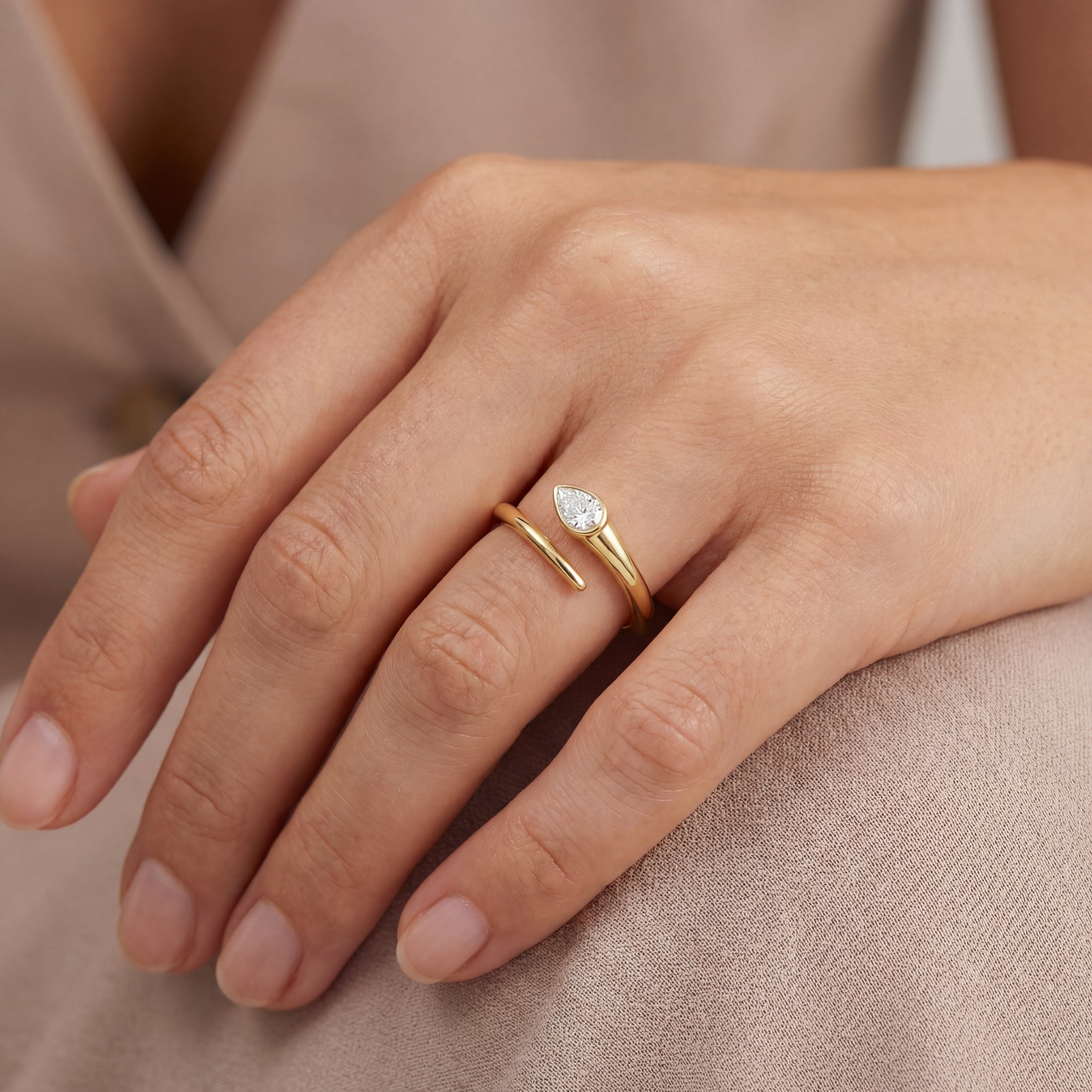 Bezel Set Pear Diamond Wrap Ring worn on a hand, showcasing the pear-shaped diamond in a 14k gold setting.