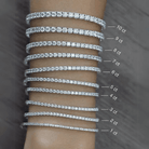 A collection of luxurious diamond tennis bracelets ranging from 1 carat to 10 carats displayed on an arm by our jewelry brand.