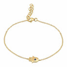 Gold Hamsa hand bracelet with sapphire stone on delicate chain, luxury jewelry piece from our collection.