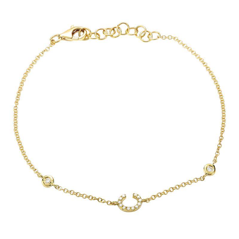 Delicate gold chain bracelet with a small horseshoe pendant by our jewelry brand, perfect for a touch of elegance and good luck.