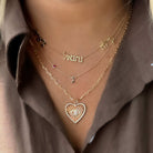 Layered gold necklaces with heart pendant and custom name jewelry from our exclusive jewelry collection.