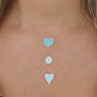 Layered gold necklaces with blue heart and eye pendants from our jewelry collection