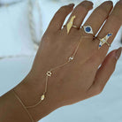 Gold and blue gemstone rings paired with a delicate star and moon hand chain by our jewelry brand.