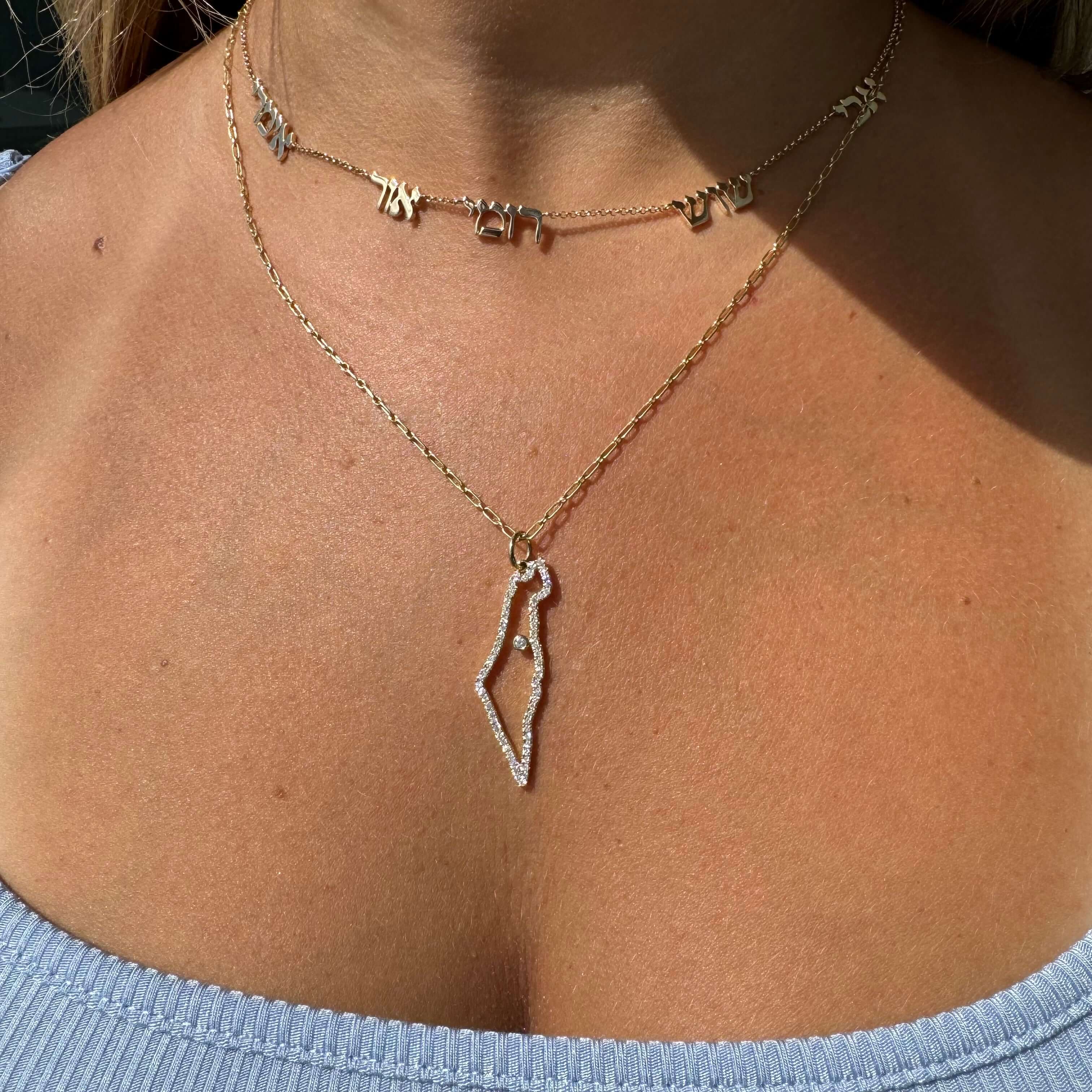 Elegant gold necklace featuring a unique Israel map pendant, worn by a model, highlighting our exclusive fine jewelry collection.