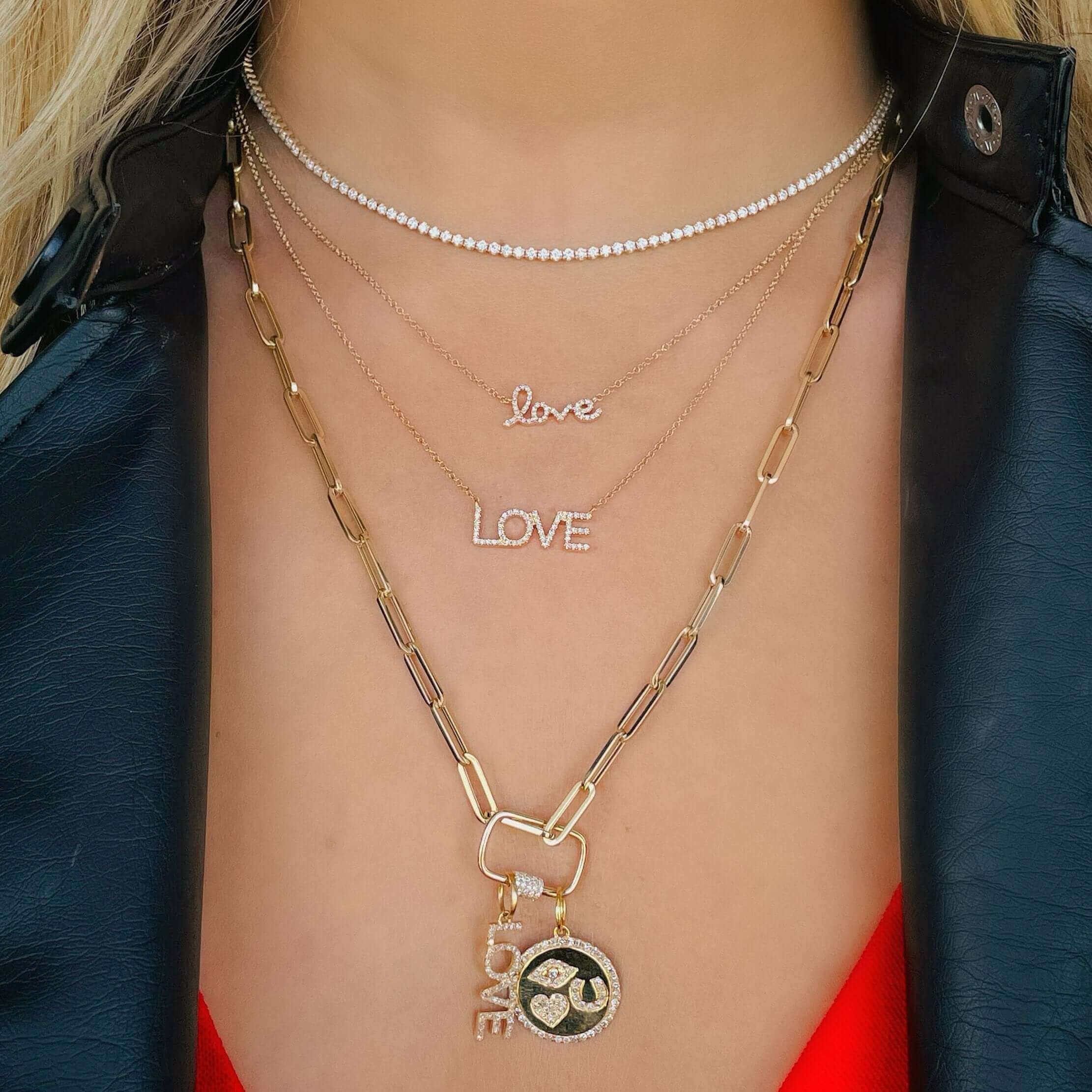 Woman wearing layered gold necklaces with "Love" pendants from our jewelry collection.