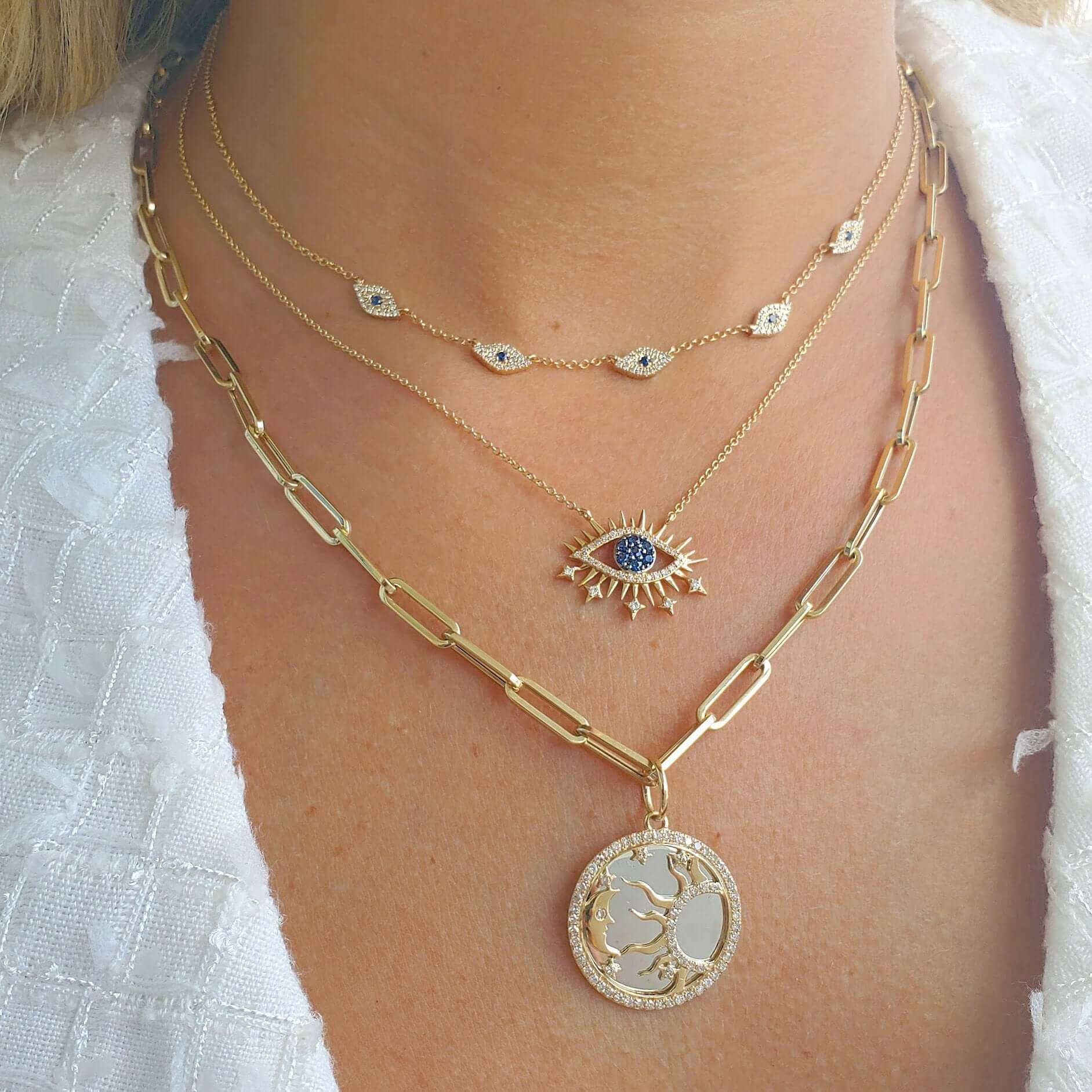 Layered necklaces featuring eye pendant and tree medallion in gold, from our exclusive jewelry collection.