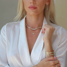 Woman showcasing elegant jewelry pieces from our brand, including layered necklaces, drop earrings, and stylish bracelets.