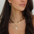 Woman wearing layered gold necklaces with delicate designs from our jewelry collection