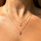 Woman wearing double-layered gold necklace with Star of David and Menorah pendants from our exclusive jewelry collection.