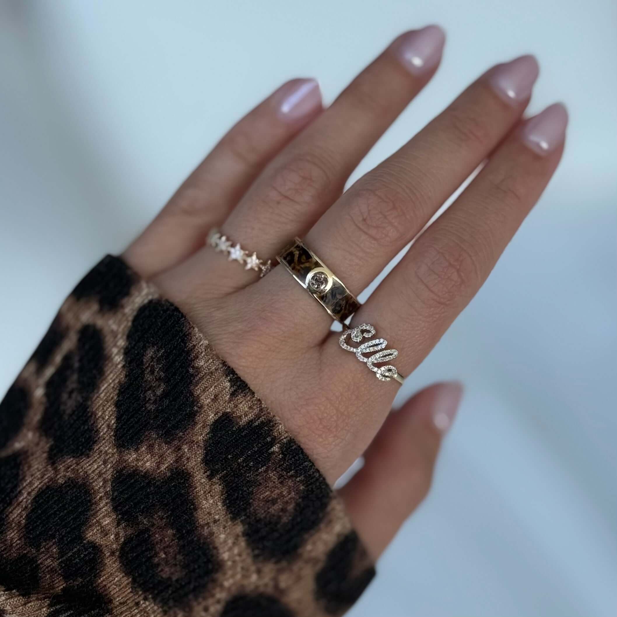 14K Gold Enamel Leopard Print Brown Diamond Ring showcased on a hand wearing trendy rings and leopard print sweater.
