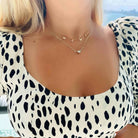 Woman wearing polka dot dress and 'MAMA' gold necklace from our jewelry collection