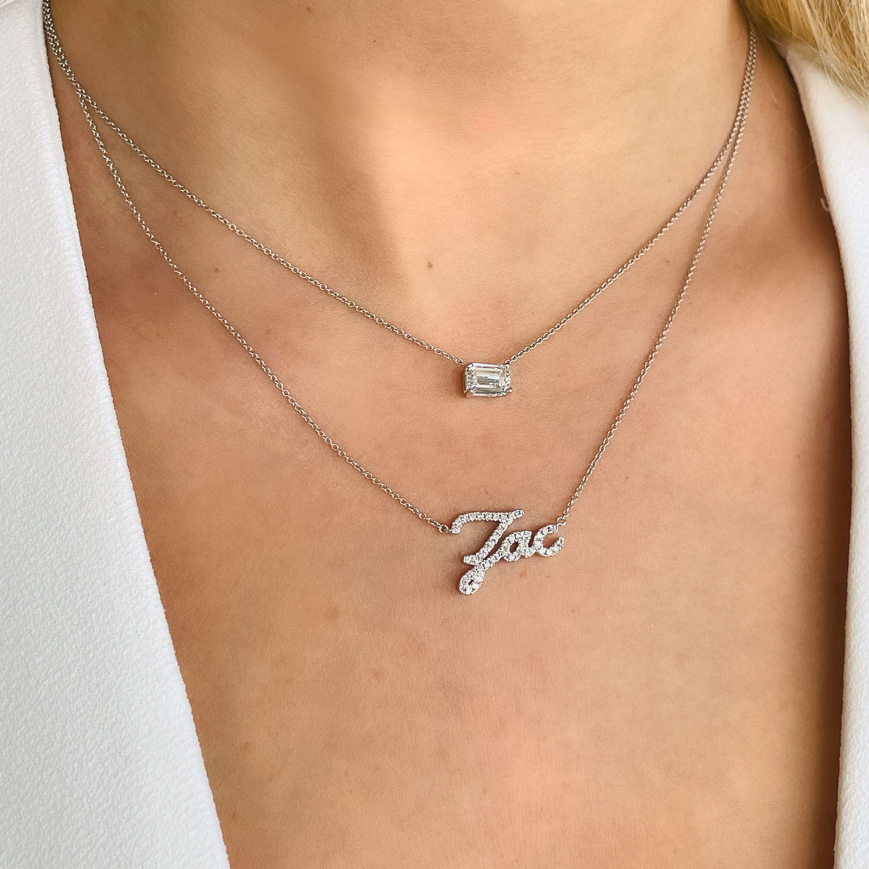 Layered silver necklaces with a custom name pendant and geometric charm from our luxury jewelry collection.