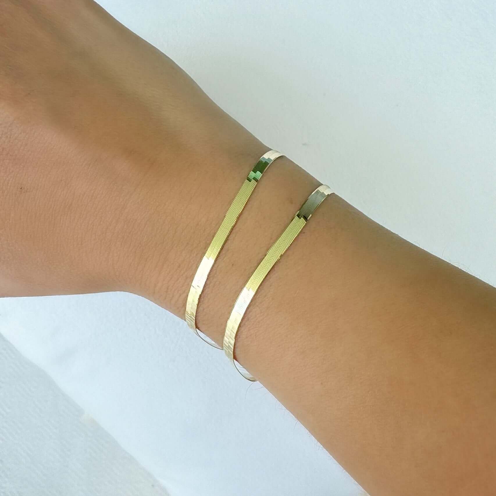 Elegant gold cuff bracelet on wrist showcasing minimalistic jewelry design.