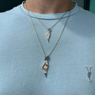 Man wearing two gold necklaces with blue and white gemstone pendants shaped like Israel, featuring a Star of David, from our jewelry collection.