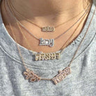 Multiple personalized Hebrew nameplate necklaces in gold and diamond designs, layered on a woman's neck.