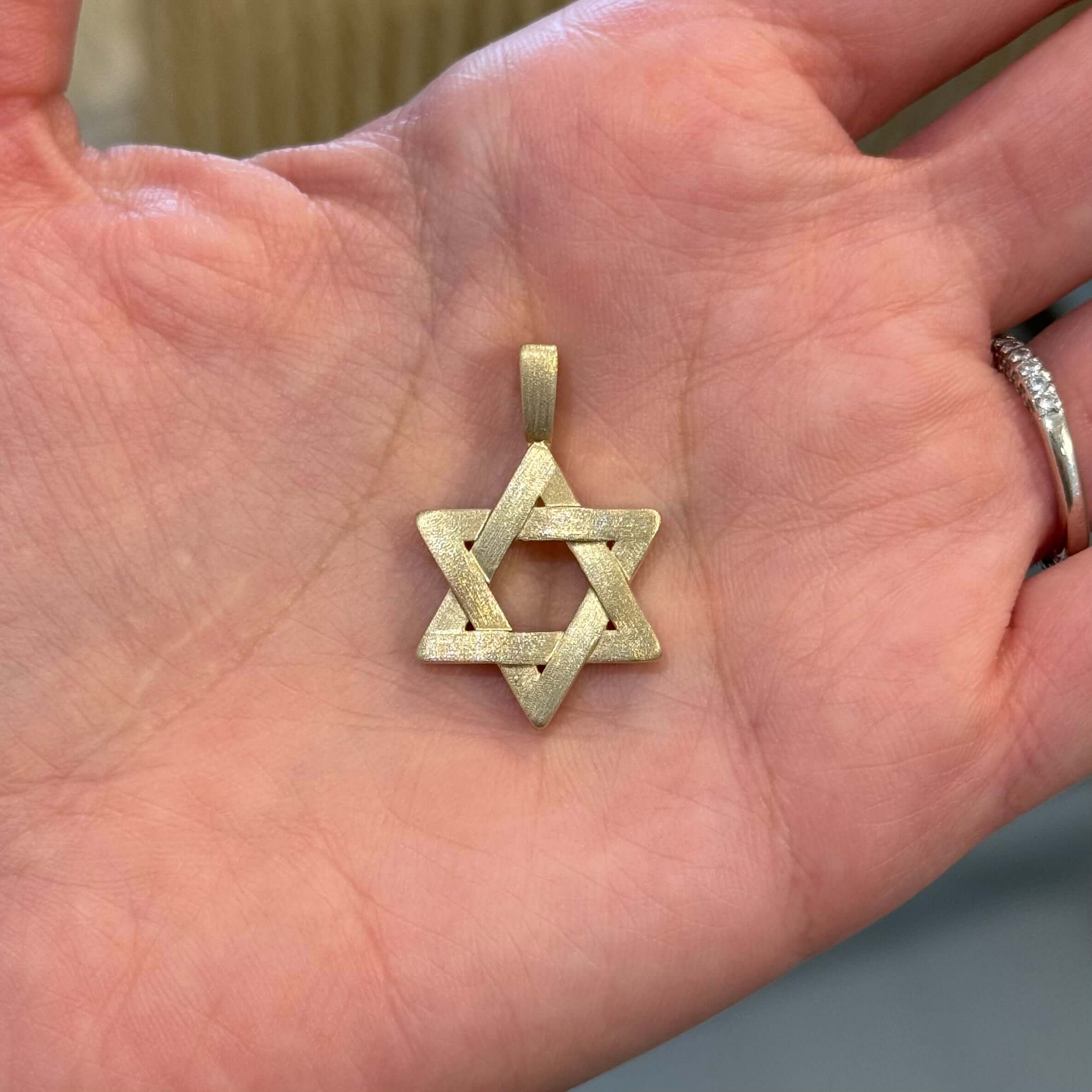 14K Gold Matte Finish Star of David Pendant © held in hand, showcasing its refined texture and symbolic design.