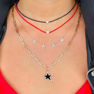 Woman wearing layered gold necklaces with a star pendant and personalized BAAM letters, showcasing our jewelry brand's stylish and unique designs