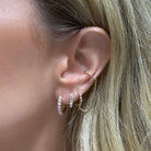 Model wearing Classic Pave Diamond Huggies by Izakov Fine Jewelry, showcasing elegant diamond detail in ear.