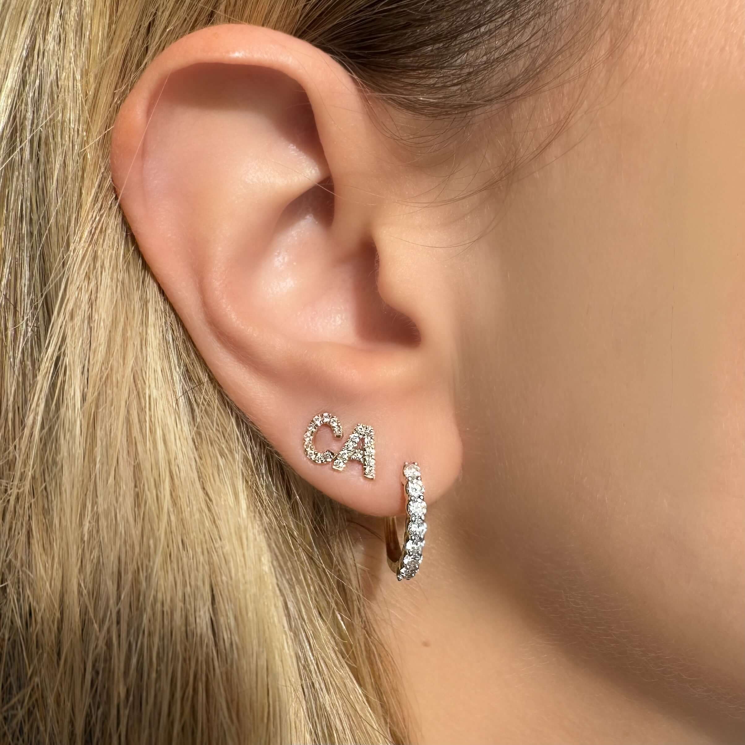 14K gold pave diamond initial earrings displaying 'CA' on a model, adding elegance and personalization to any outfit.