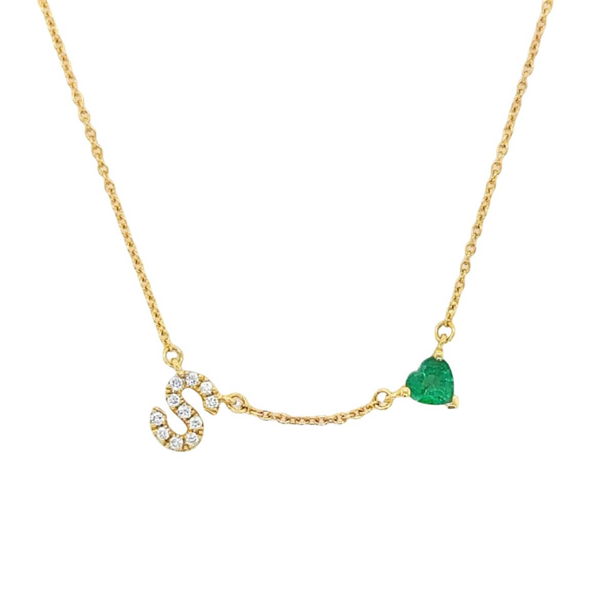 Gold necklace with diamond-studded "S" and heart-shaped emerald pendant from our jewelry brand collection.