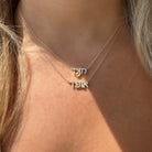 Elegant double-layer gold Hebrew name necklaces on woman's neck, featuring delicate chain design from our exclusive jewelry collection.