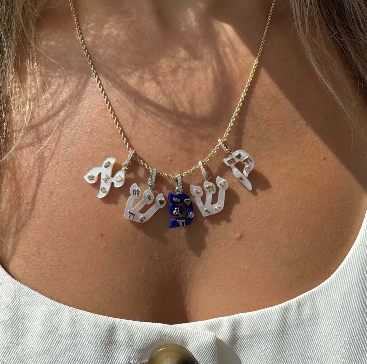 Personalized Charms Hebrew Gemstone Initial Pendant featuring symbolic charms in various colors on a gold chain.