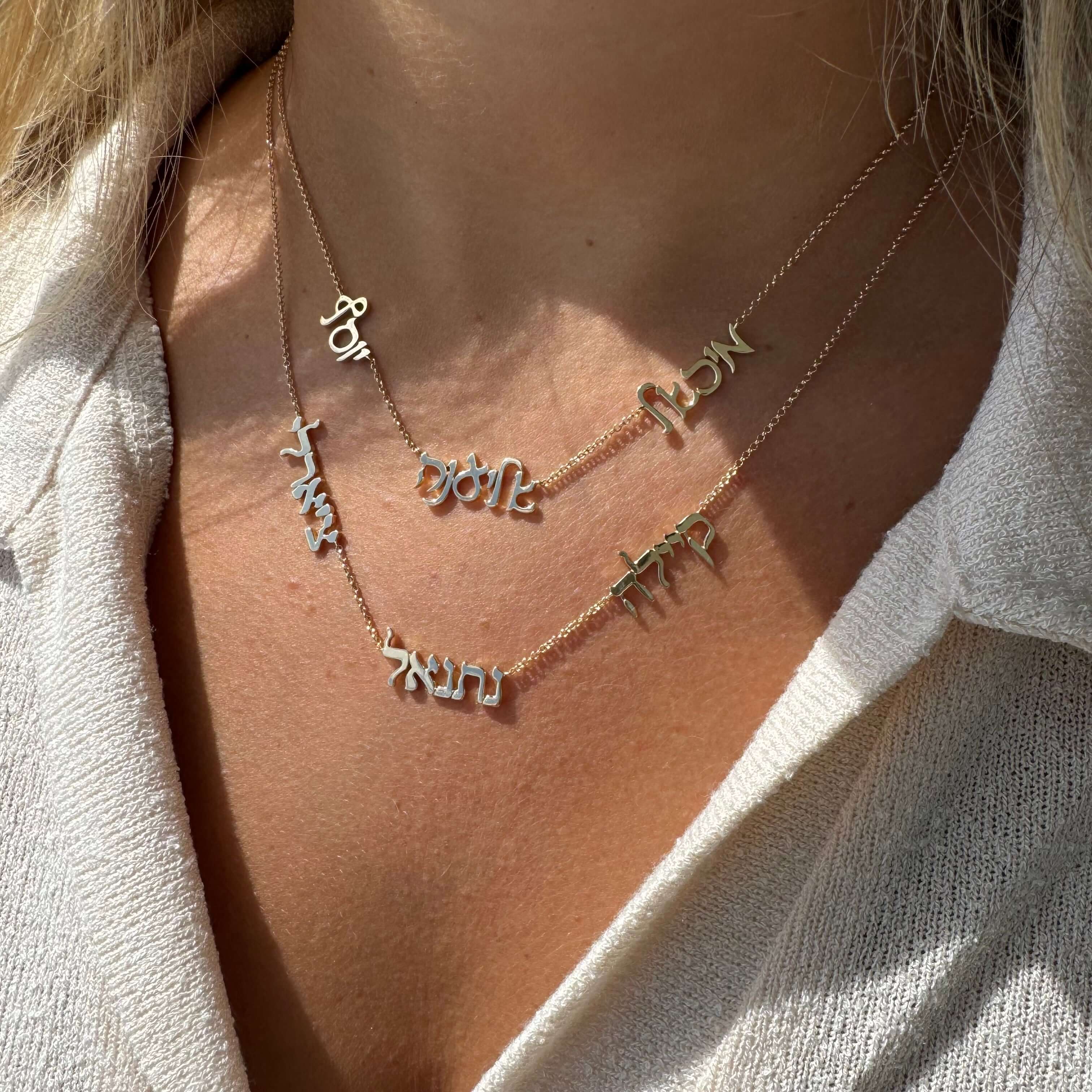 Woman wearing layered necklaces with elegant personalized name pendants from our jewelry collection