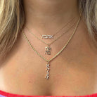 Woman wearing gold layered necklaces with Hebrew name pendants from our jewelry brand.