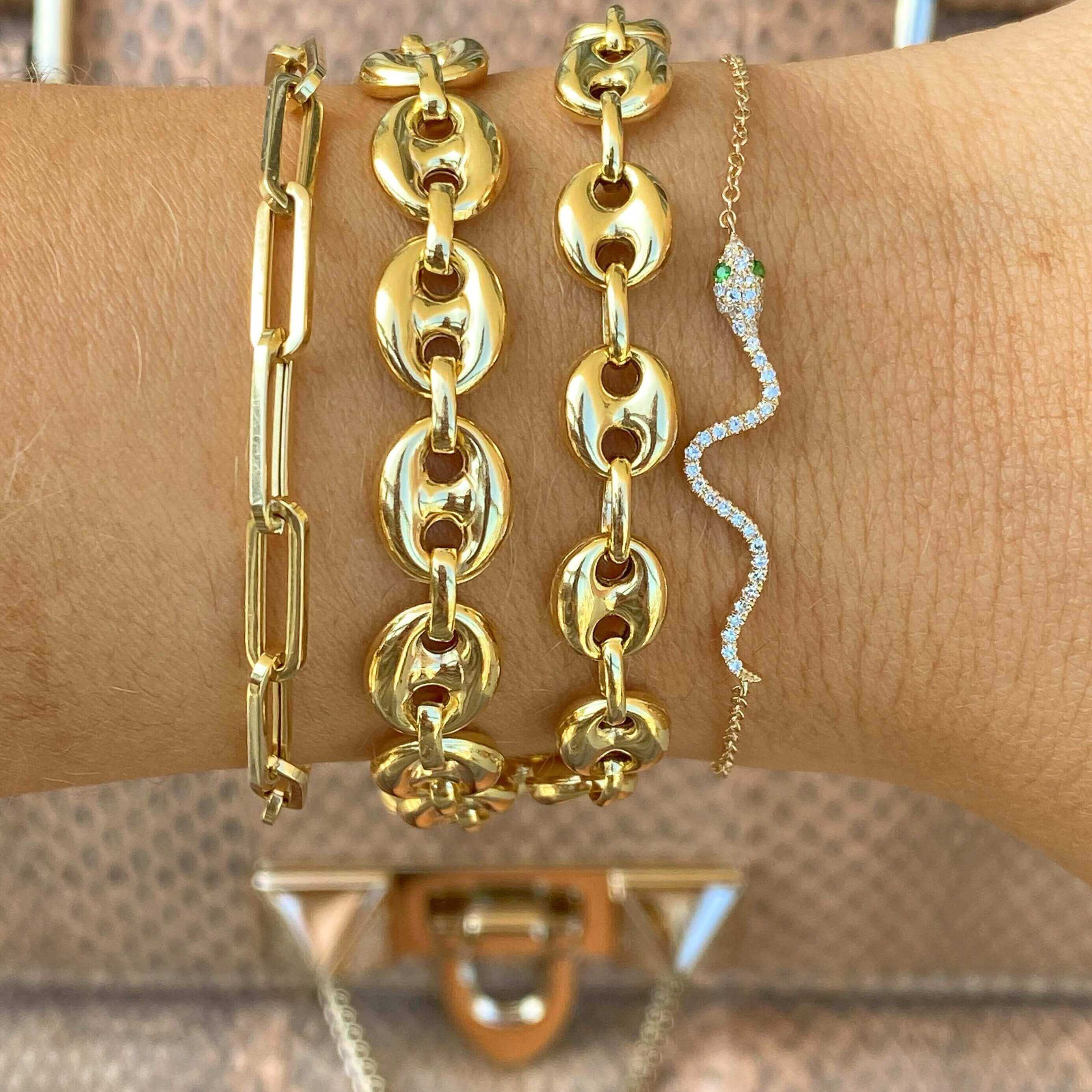 Stylish gold chain bracelets and a sparkling snake bracelet on wrist, showcasing luxury jewelry from our exclusive collection.