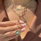 Model wearing a Radiating Evil Eye Diamond Necklace Charm, showcasing its gold design and mother-of-pearl center.