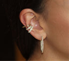 Woman wearing elegant gold and diamond cuff and hoop earrings from our jewelry collection