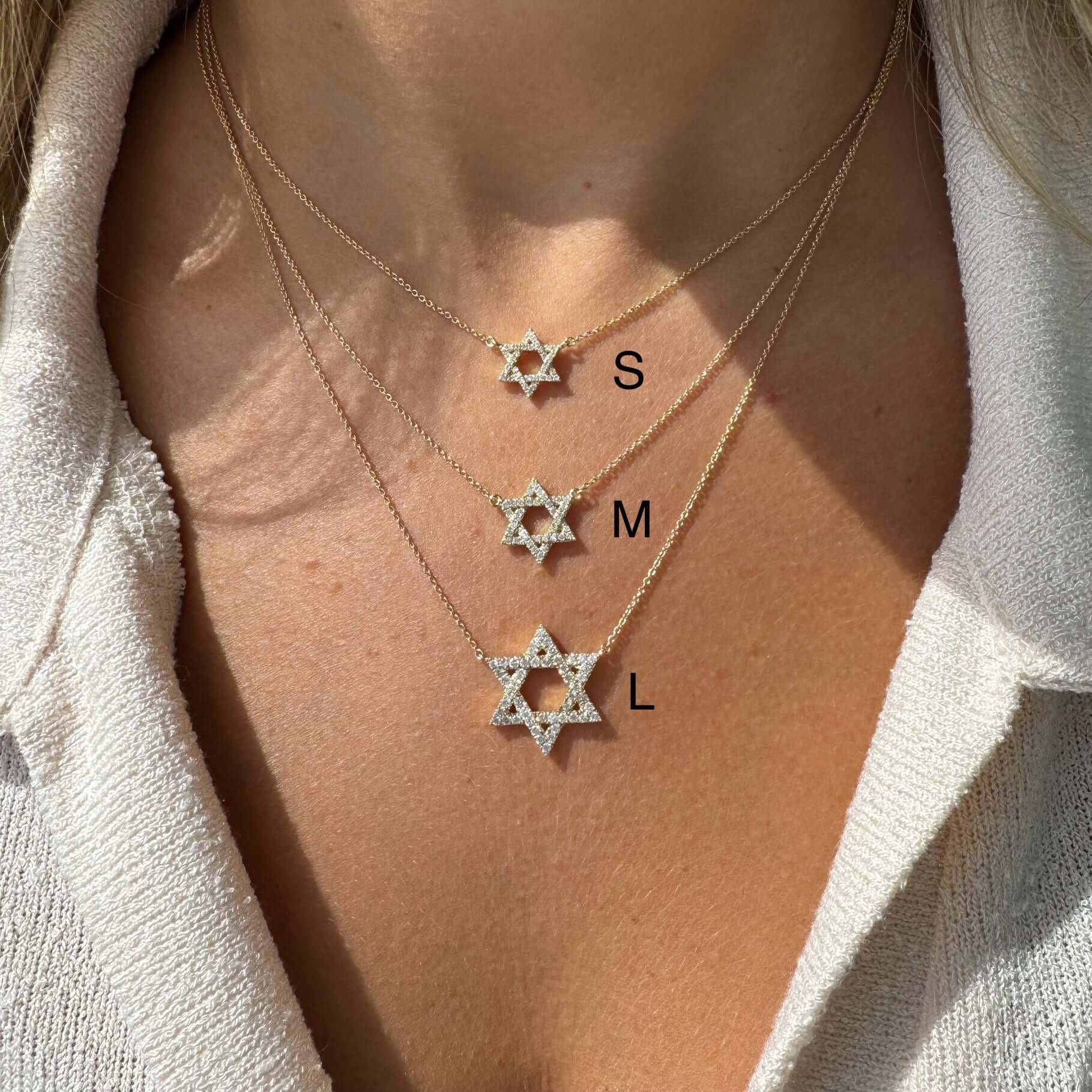 Woman wearing three diamond Star of David necklaces in small, medium, and large sizes from our jewelry collection