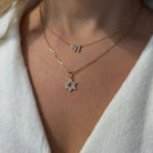 Radiating Star of David Diamond Pendant showcased in layered necklace with delicate gold chain.