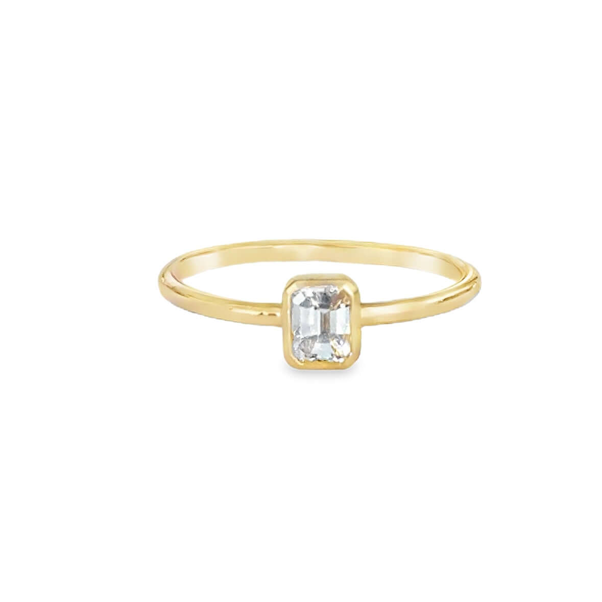 18K gold petite emerald cut diamond bezel ring showcasing a sleek design with a 0.28 carat diamond.