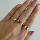 18K gold open ring set with diamond accents, featuring 'Elle' inscription and heart details, worn on a hand.