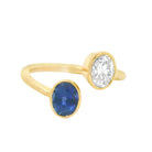 18K gold Toi et Moi wrap ring featuring a diamond and sapphire in elegant bezels. Unique statement piece for jewelry lovers.