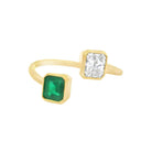 18K gold Toi et Moi ring featuring radiant cut diamond and emerald, elegant wrap design showcasing luxury gemstones.