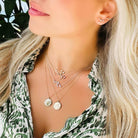 Model showcasing layered necklaces with zodiac charms and delicate earrings, highlighting celestial elegance and style.