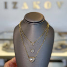 Floating Solitaire Lab-Grown Diamond Bezel Necklace showcased on a display with gold chains and sparkling diamonds.