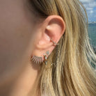 Diamond Heart Dangling Bezels Ear Cuff Earring worn in a stylish ear arrangement, showcasing elegant gold and diamond design.