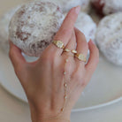 Baguette Diamond Hebrew Initial Signet Pinky Ring showcased with pastries, featuring unique gold and diamond design.