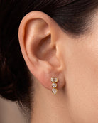 East West Emerald Cut and Pear Diamond Bezel Drop Earrings in 14k yellow gold