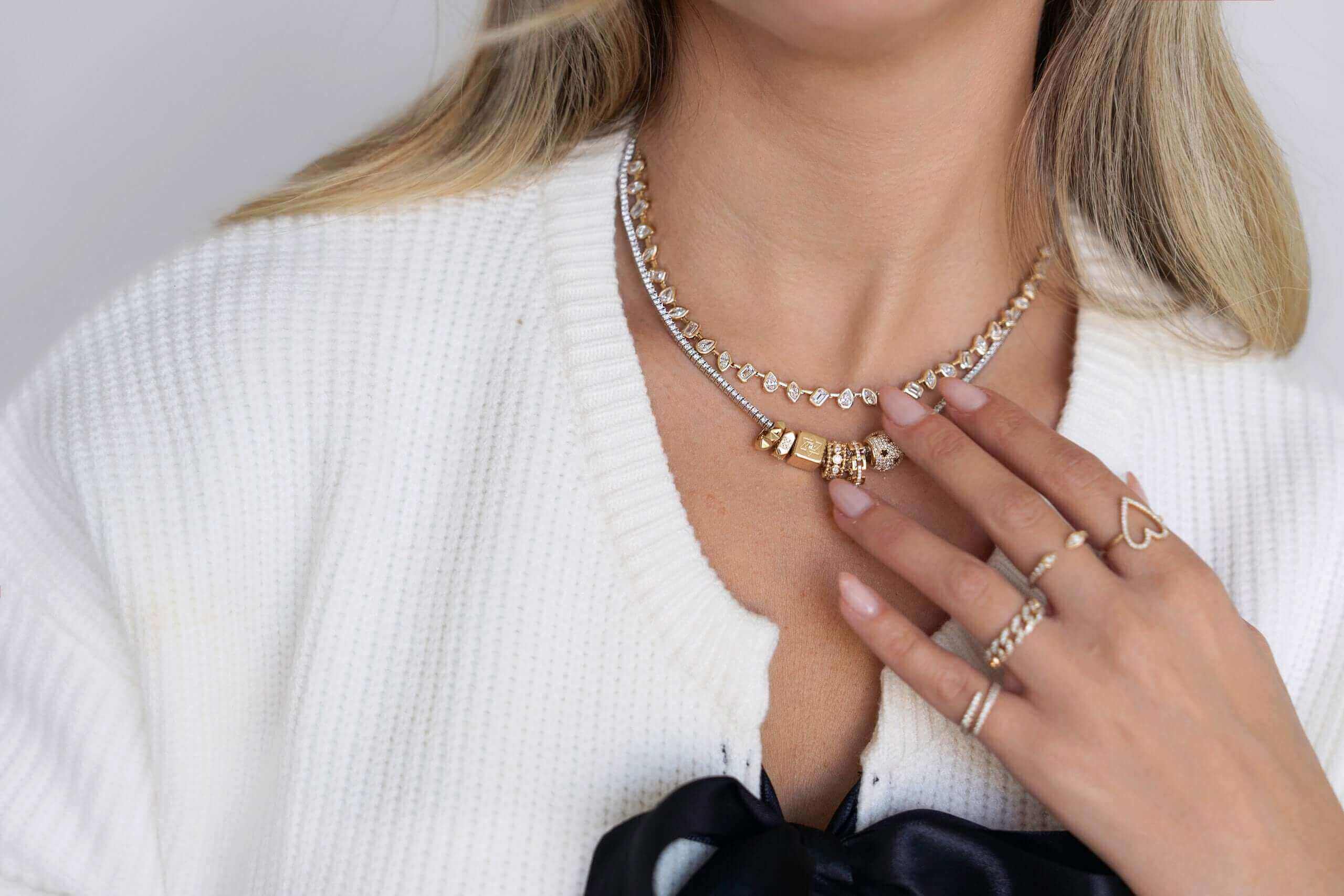 Model showcasing Izakov Fine Jewelry, featuring a stylish necklace and elegant rings.